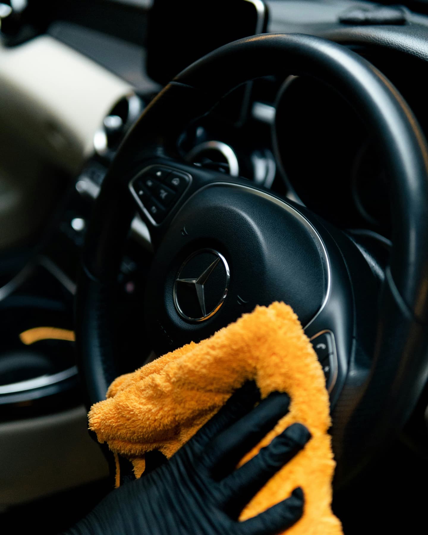 Interior steering wheel being wiped with a microfibre cloth