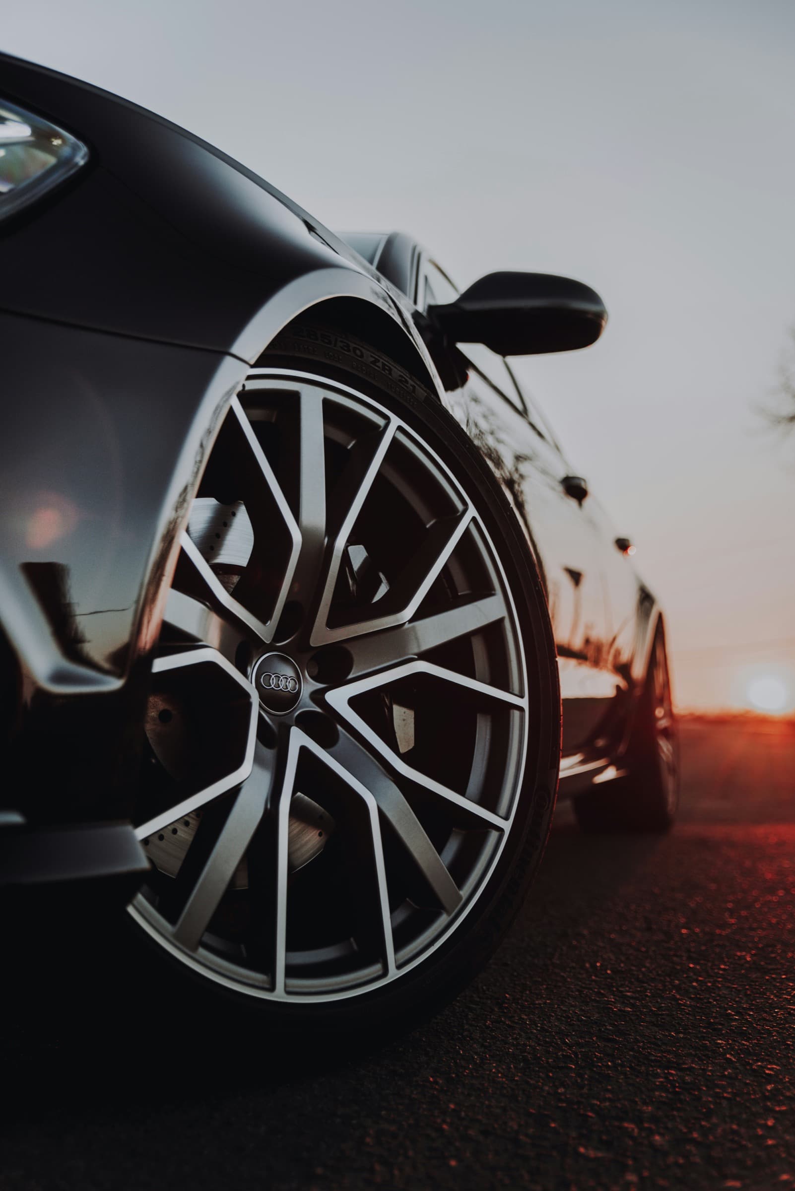 Close-up of a black Audi wheel in sunset light